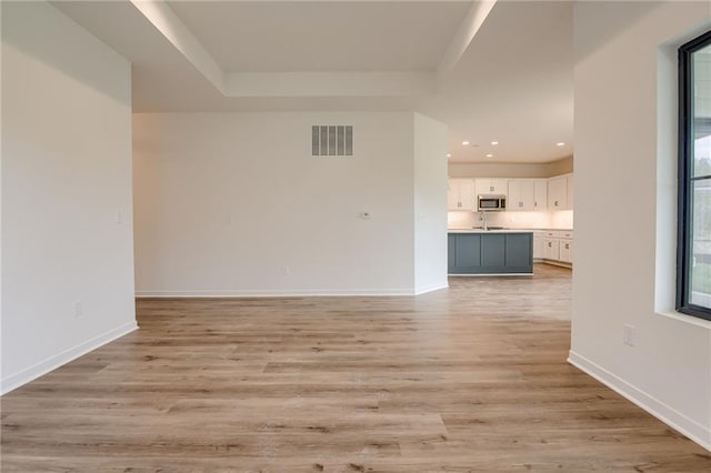 unfurnished living room featuring baseboards, recessed lighting, light wood-style flooring, and visible vents