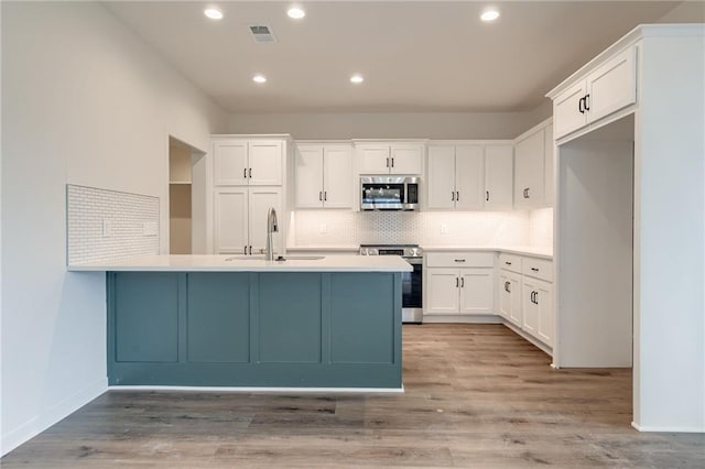 kitchen with visible vents, a sink, white cabinetry, and stainless steel appliances