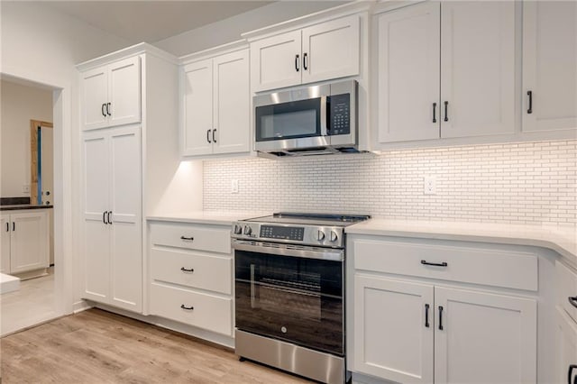 kitchen featuring light countertops, stainless steel appliances, white cabinetry, and light wood-style flooring