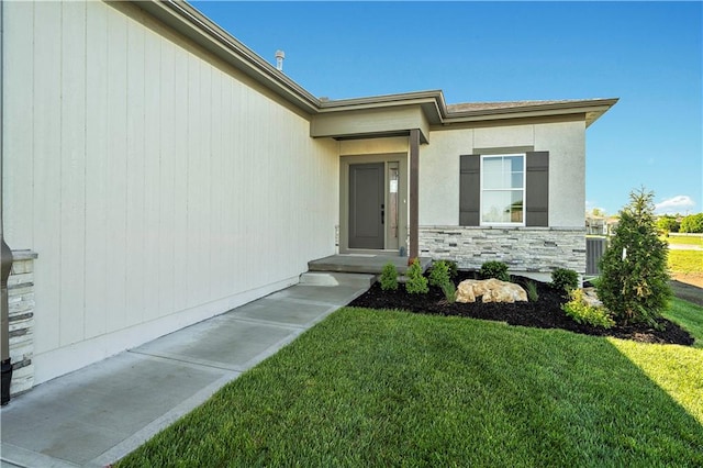 view of exterior entry with a lawn