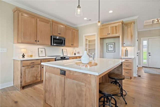 kitchen with pendant lighting, crown molding, appliances with stainless steel finishes, backsplash, and a kitchen island