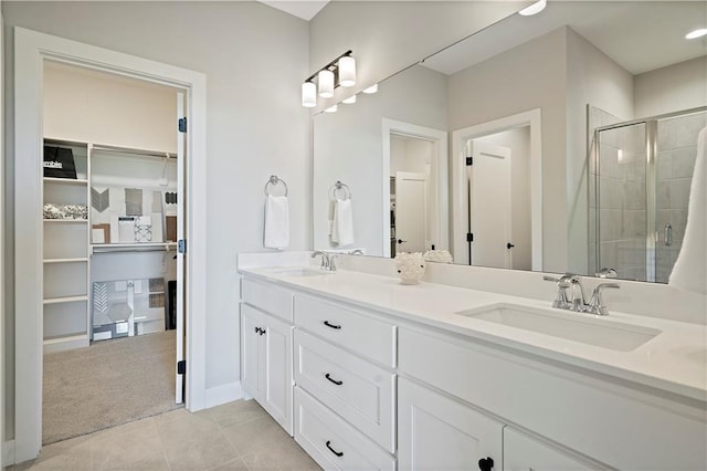 bathroom with an enclosed shower, vanity, and tile patterned floors