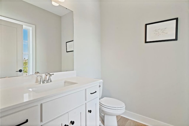 bathroom featuring vanity, wood-type flooring, and toilet