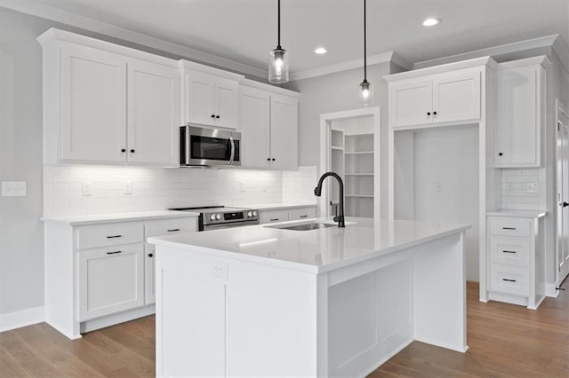 kitchen featuring a kitchen island with sink, sink, appliances with stainless steel finishes, white cabinets, and pendant lighting