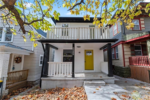 view of property with a porch and a balcony