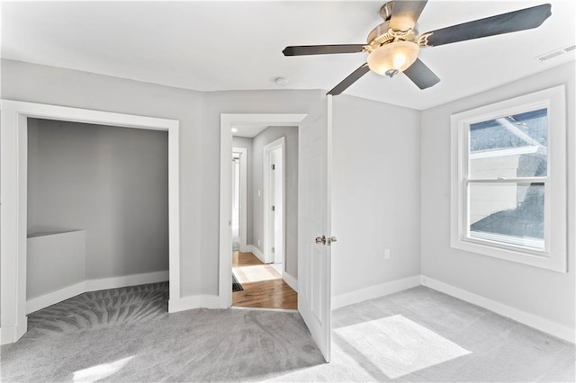 unfurnished bedroom featuring a closet, ceiling fan, and light colored carpet