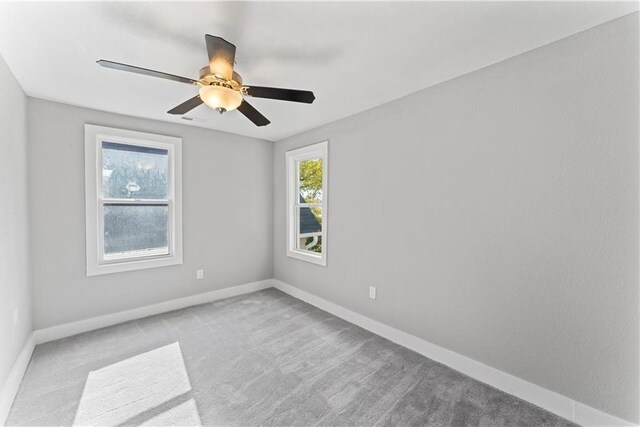 carpeted spare room featuring ceiling fan