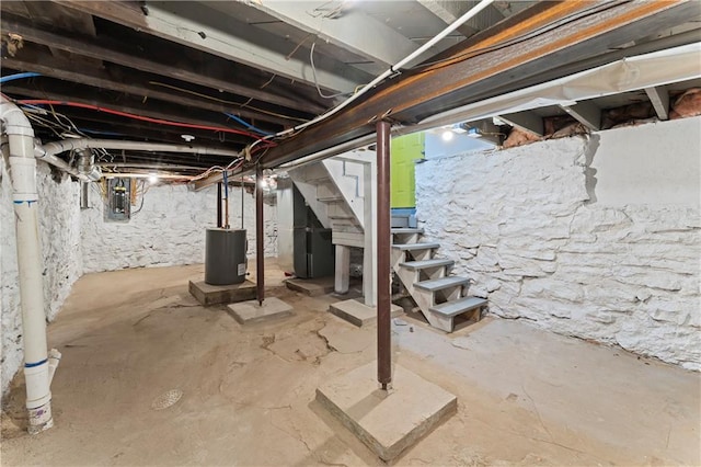 basement featuring electric panel and water heater