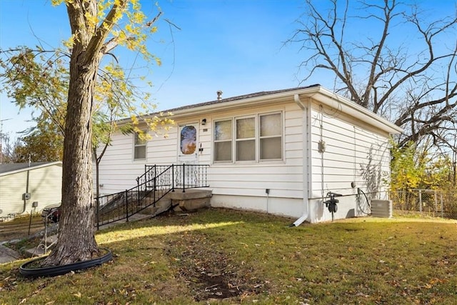 view of front facade featuring a front yard and central AC unit