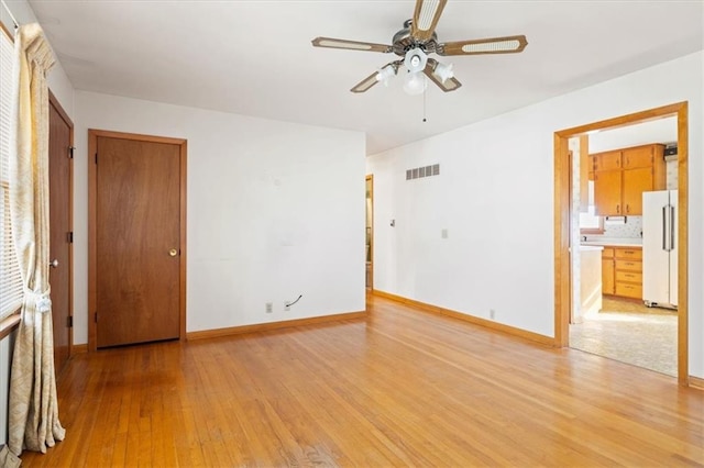 spare room featuring light hardwood / wood-style flooring and ceiling fan