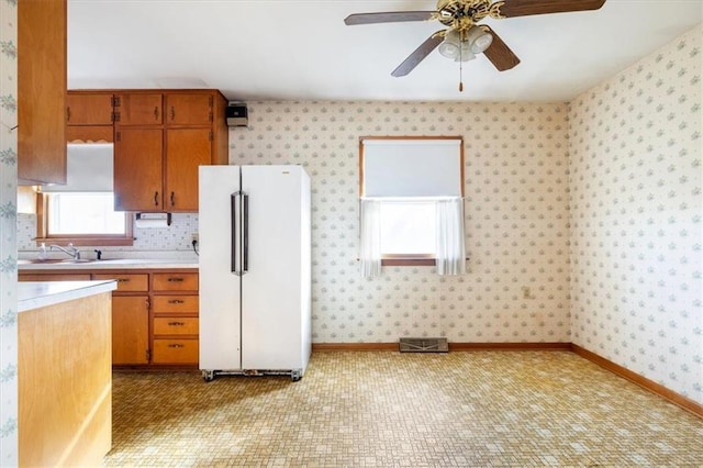 kitchen with ceiling fan, sink, and white refrigerator