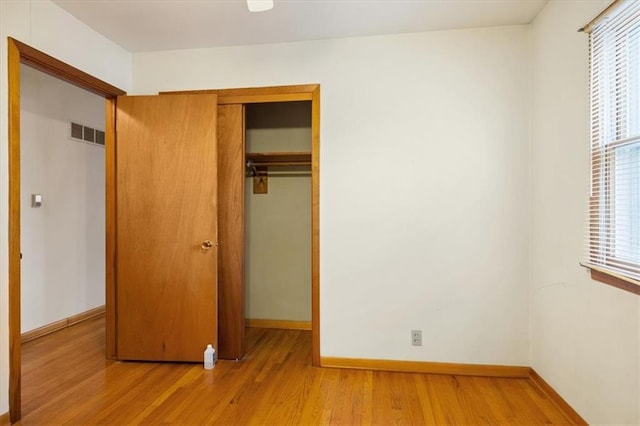 unfurnished bedroom with light hardwood / wood-style flooring and a closet