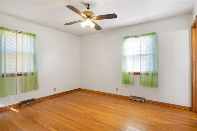 unfurnished room with light hardwood / wood-style flooring, ceiling fan, and a wealth of natural light