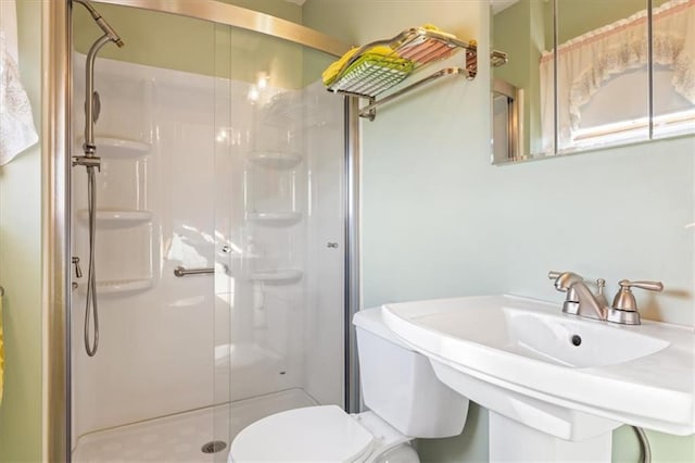 bathroom featuring sink, toilet, and an enclosed shower