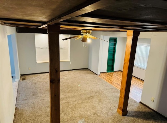 basement featuring hardwood / wood-style floors and ceiling fan