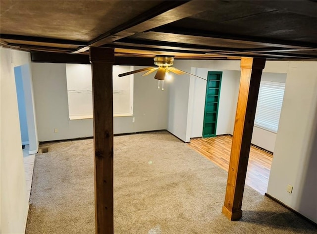 interior space with baseboards, a ceiling fan, and carpet