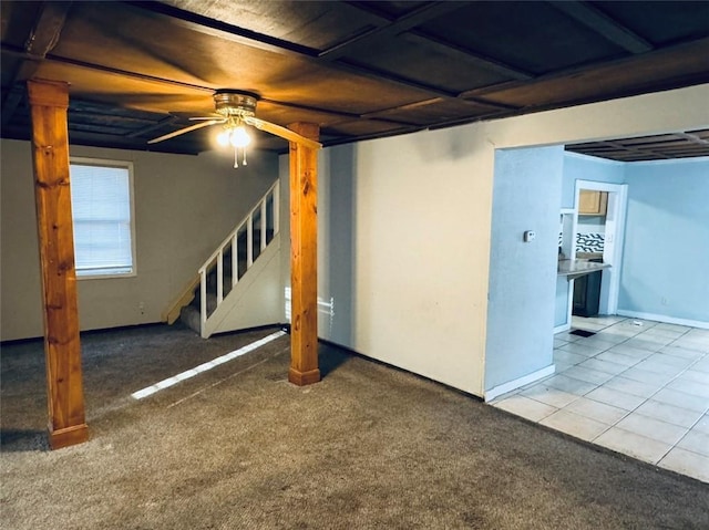 basement with carpet flooring, baseboards, a ceiling fan, and stairway