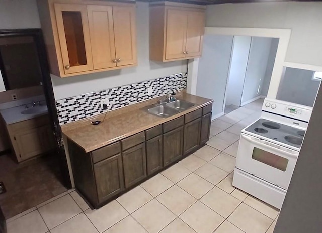 kitchen with tasteful backsplash, light tile patterned flooring, a sink, and white range with electric cooktop