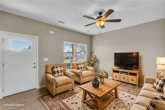 living room with ceiling fan and light hardwood / wood-style flooring