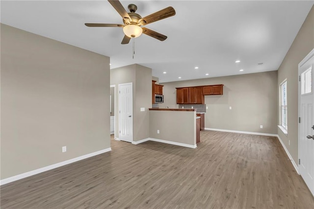 unfurnished living room featuring hardwood / wood-style floors and ceiling fan