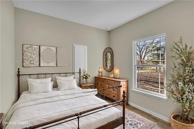 bedroom with multiple windows and hardwood / wood-style floors