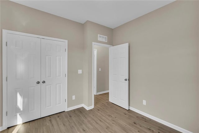 unfurnished bedroom featuring light wood-type flooring and a closet