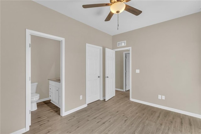 unfurnished bedroom featuring light wood-type flooring, connected bathroom, and ceiling fan