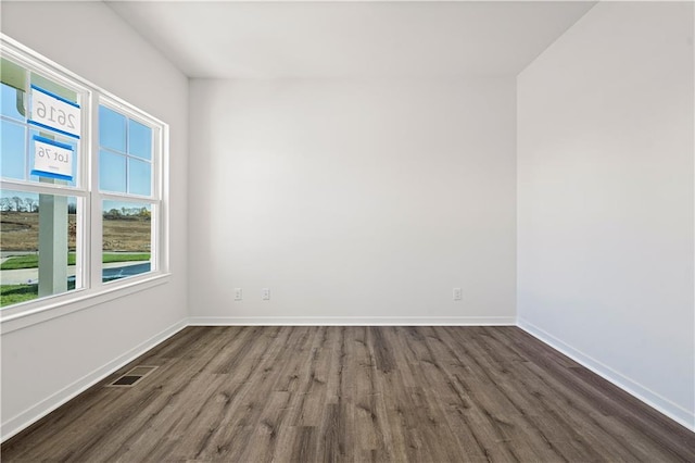 unfurnished room with dark wood-type flooring