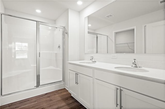 bathroom with hardwood / wood-style flooring, vanity, and a shower with shower door