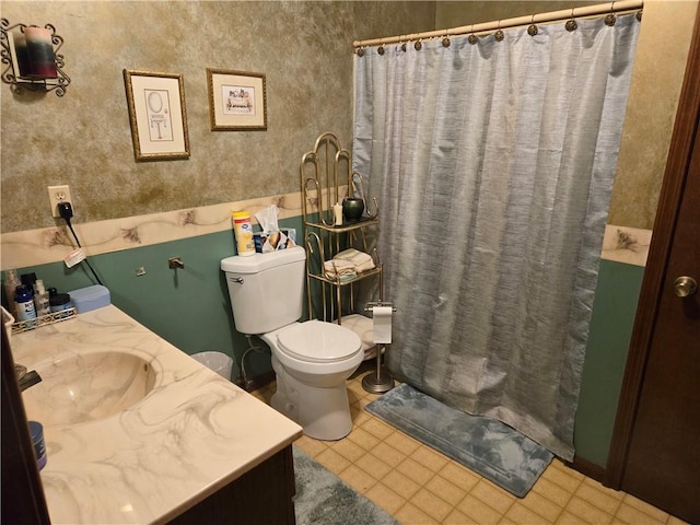 bathroom featuring toilet, walk in shower, and vanity