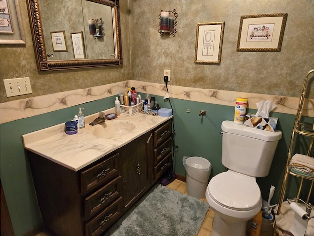 bathroom with toilet, vanity, and tile patterned flooring