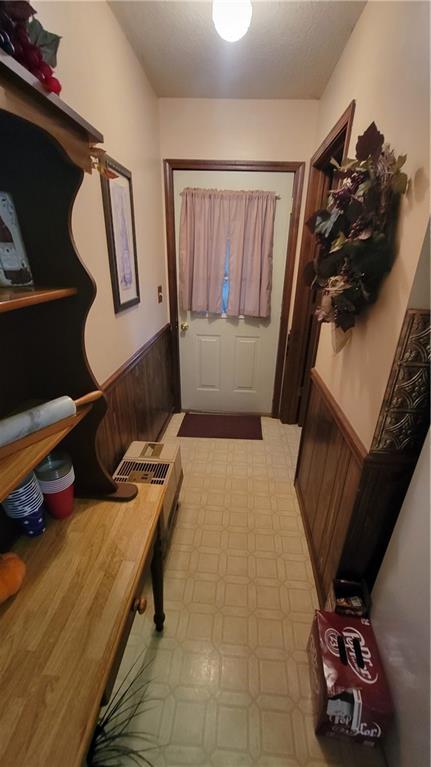 doorway to outside featuring wooden walls