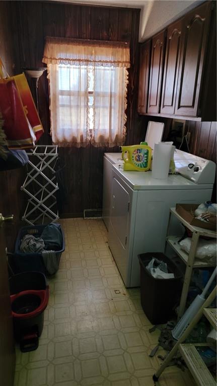 laundry room featuring washer and clothes dryer and cabinets