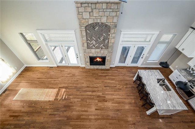 20473 199th St, Tonganoxie, KS 66086 - living area featuring wood finished floors, a stone fireplace, baseboards, and french doors