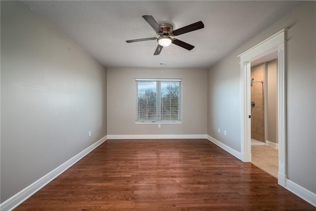 20473 199th St, Tonganoxie, KS 66086 - unfurnished room with dark wood-type flooring, ceiling fan, baseboards, and a textured ceiling