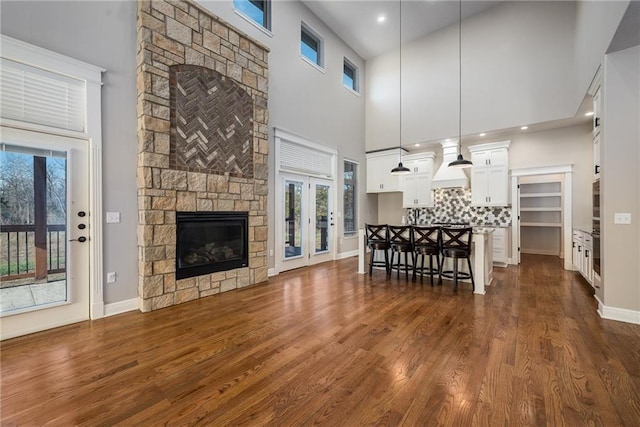 20473 199th St, Tonganoxie, KS 66086 - living area with a towering ceiling, dark wood finished floors, a fireplace, french doors, and baseboards