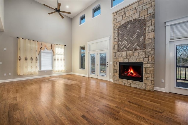 20473 199th St, Tonganoxie, KS 66086 - unfurnished living room featuring ceiling fan, a high ceiling, a fireplace, wood finished floors, and baseboards