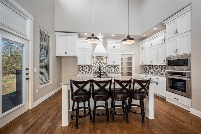 20473 199th St, Tonganoxie, KS 66086 - kitchen featuring stainless steel appliances, custom range hood, a towering ceiling, decorative backsplash, and white cabinetry