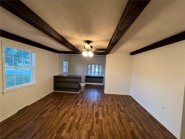 unfurnished room with dark hardwood / wood-style floors, beam ceiling, a textured ceiling, and ceiling fan