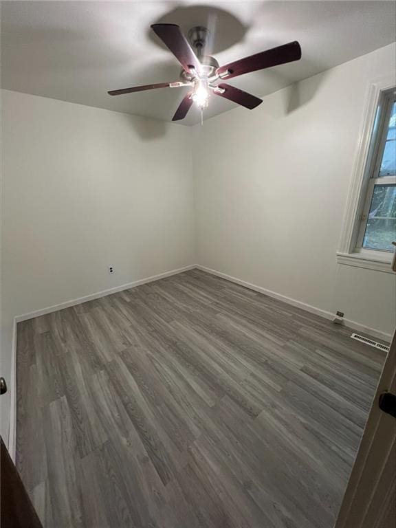 unfurnished room featuring dark hardwood / wood-style floors and ceiling fan