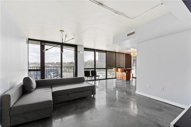 living room with expansive windows, a notable chandelier, and a healthy amount of sunlight