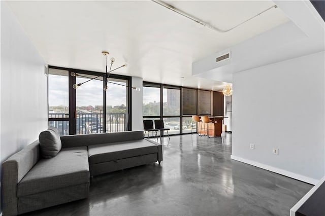 living area with plenty of natural light, floor to ceiling windows, concrete flooring, and baseboards