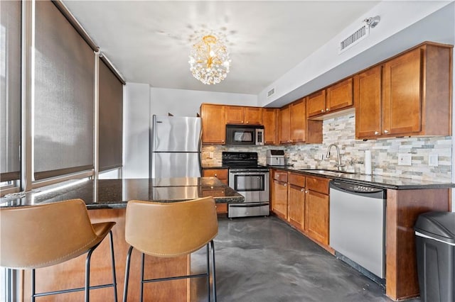 kitchen with a sink, brown cabinetry, stainless steel appliances, decorative backsplash, and visible vents
