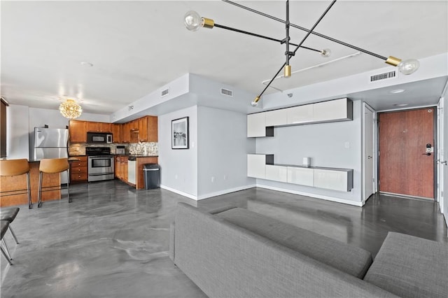 living area with visible vents, baseboards, and finished concrete floors