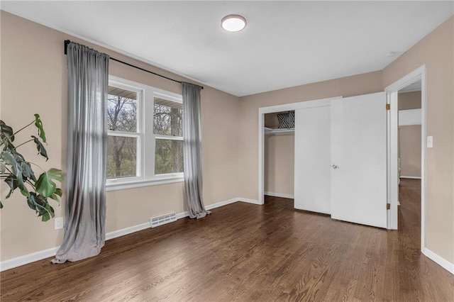 unfurnished bedroom featuring dark hardwood / wood-style floors and a closet