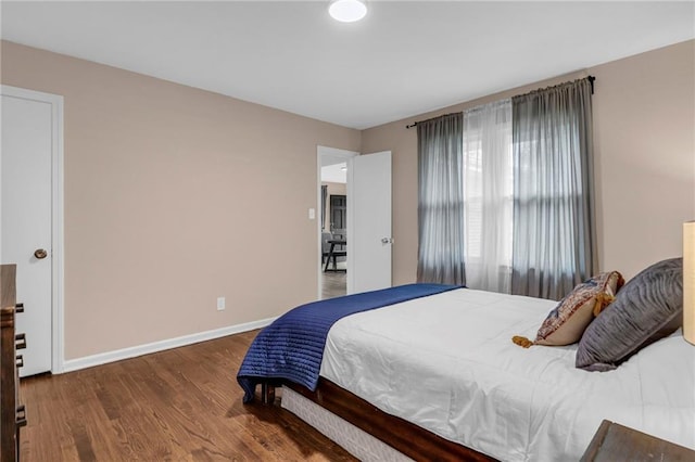 bedroom with dark hardwood / wood-style floors