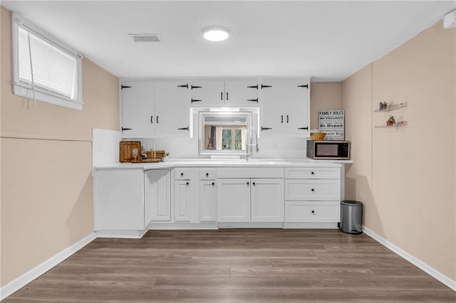 kitchen with white cabinetry, sink, and light wood-type flooring