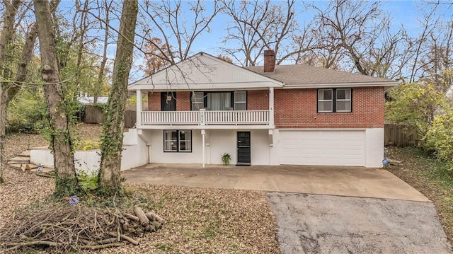 view of front of property with a garage, brick siding, driveway, and a chimney