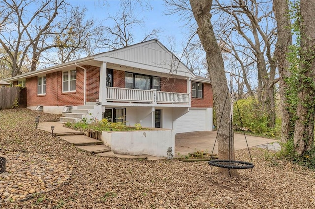 view of front of house with driveway, an attached garage, and brick siding