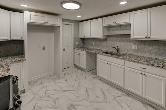 kitchen with sink, white cabinets, and light stone countertops